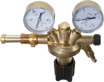 A close-up studio shot of a brass pressure regulator with two gauges, set against a white background.