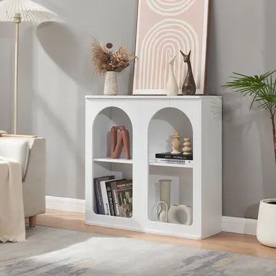 A white sideboard with arched openings is displayed in a living room setting, next to a sofa and a floor lamp.