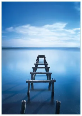 Produktbild von Wallario Premium Glasbild, freischwebende Optik, kräftige Farben, Größe 100 x 70 cm Motiv Rustikaler Holzsteg im blauen See
