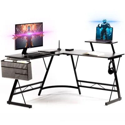 A black L-shaped gaming desk with a monitor, laptop, keyboard, and headphones.