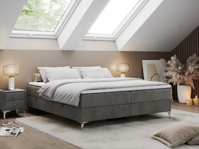 A bedroom scene with a bed as the main focus, set in an attic room with skylights.