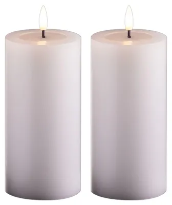Imagen del producto de Conjunto de 2 velas LED grandes, de color blanco, con cera real y llama móvil que parpadea. Incluye función de temporizador de 6 horas y luz blanca cálida. Diámetro: 7,5 cm, altura: 15 cm. Requiere 2 pilas AA. Reflejo de cera real