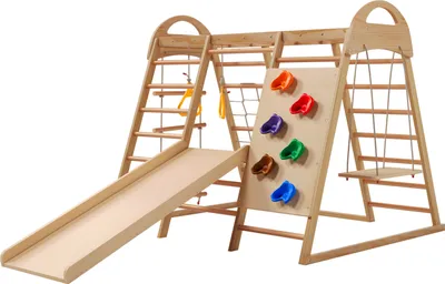 A wooden indoor playground structure with a slide, climbing ladder, climbing net, and rock climbing holds.