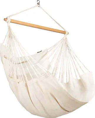 A cream-colored hammock chair hanging from a wooden spreader bar.