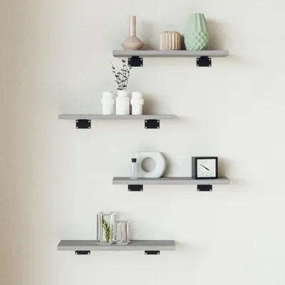 Four gray shelves mounted on a white wall, each with decorative items.