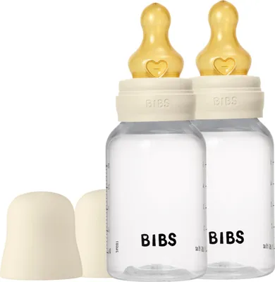 Two baby bottles with yellow nipples and ivory caps are shown against a white background.