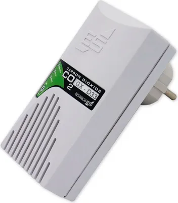 A white carbon dioxide detector plugged into an outlet.