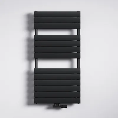A black radiator is mounted on a white wall.