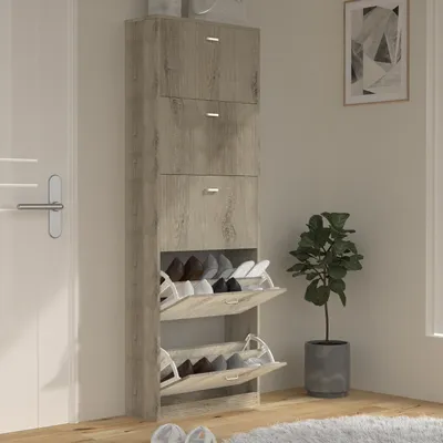 A tall, narrow shoe cabinet with multiple flip-down compartments is shown in a room setting, next to a white door and a potted plant.