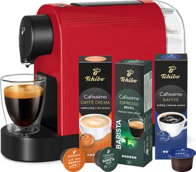 A red Tchibo Cafissimo coffee machine with coffee capsules and a glass of coffee.