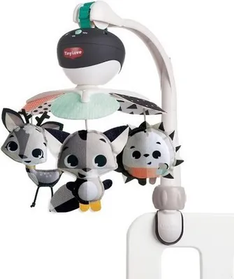 A baby mobile with stuffed animal toys attached to a stand, clipped onto the side of a crib.