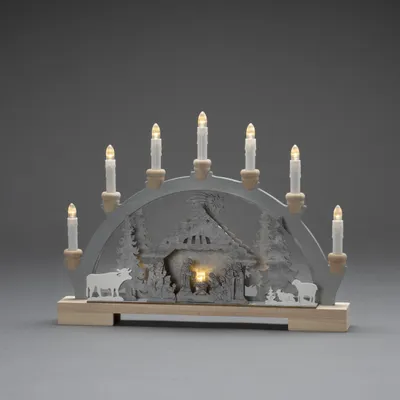 Produktbild von Konstsmide LED Holzsilhouette, "Krippe", wählbare Energiefunktion, 7 klare Birnen, 6H Timer, 10 warm weiße Dioden, 3V Innentrafo/batteriebetrieben, 0,6W, transparentes Kabel, Batterie: 2 x AA 1,5V (exkl.)- 3261-320