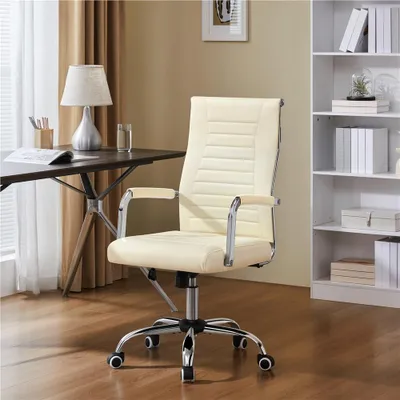An office chair is placed next to a desk with a lamp and some books on it. A bookshelf is visible in the background.