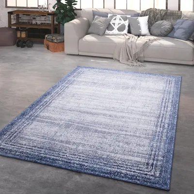 A living room with a couch and a rug on the floor.
