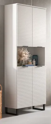 A tall, white cabinet with ribbed doors and a central open shelf displaying decorative items.