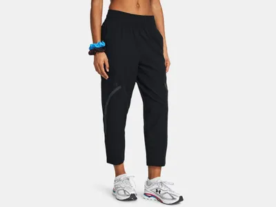 A woman wearing black athletic pants and white sneakers, shown from the side.