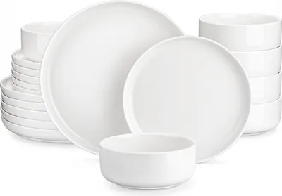 A set of white porcelain dishes, including plates and bowls, neatly arranged.
