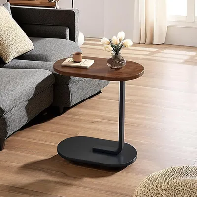 A small C-shaped side table with a wooden top and black base is placed next to a gray sofa in a living room.
