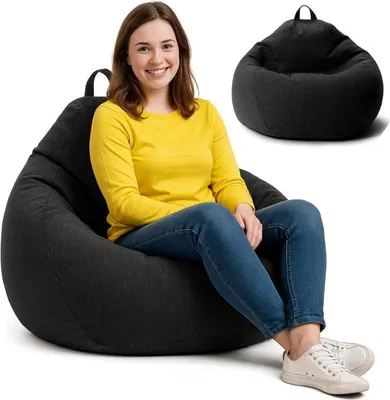 A woman is sitting on a black beanbag chair, with another black beanbag chair shown in the background.