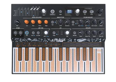 A top-down view of a black Arturia Microfreak synthesizer with orange and brown keys, set against a white background.