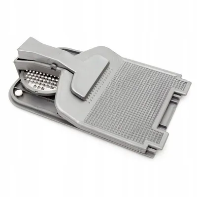 A gray plastic kitchen tool, likely a grater and fish scaler, is shown against a white background.