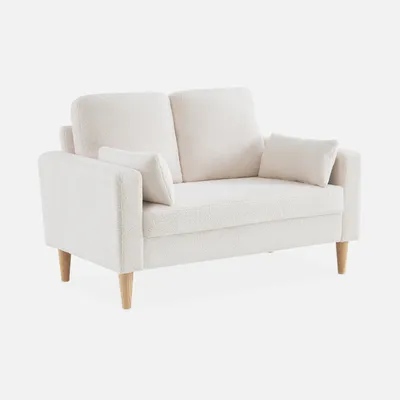 A cream-colored, two-seater sofa with bouclé teddy fabric and wooden legs, shown against a white background.