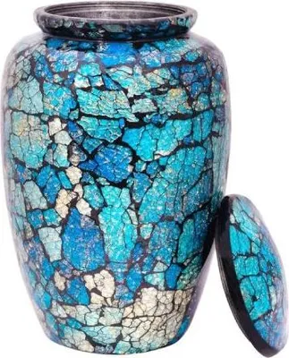 A decorative urn with a mosaic-like pattern of blue and white pieces, with its lid placed next to it.