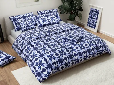 A neatly made bed with blue and white patterned bedding, pillows, and a decorative framed picture of the same pattern on a nightstand.