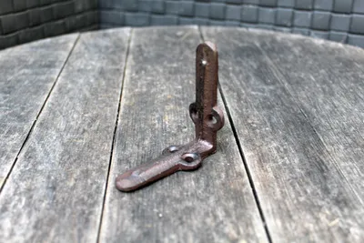A single corner bracket sits on a weathered wooden surface.