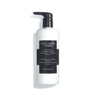A white bottle of shampoo with a black pump dispenser and a black label.