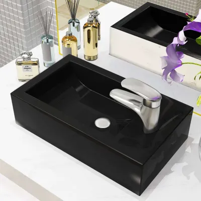 A black rectangular sink with a silver faucet is shown on a white countertop.