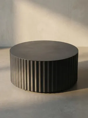 Nahaufnahme der Kante des schwarzen Metall-Couchtischs, die den sauberen Übergang von der glatten Platte zur texturierten Seite zeigt._#sku_BARWL6.760#