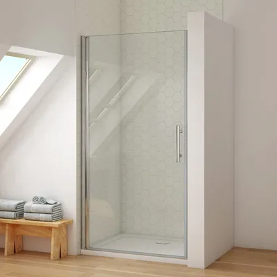 A shower enclosure with a glass door and silver handle, set in a bathroom with a slanted ceiling and skylight.