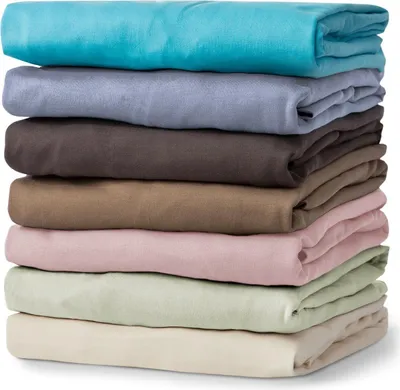 A stack of folded bed sheets in various colors.