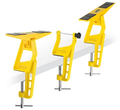 Three yellow ski vises are displayed on a white surface.