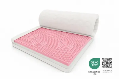 A mattress topper with a textured surface, partially unrolled, on a white background.