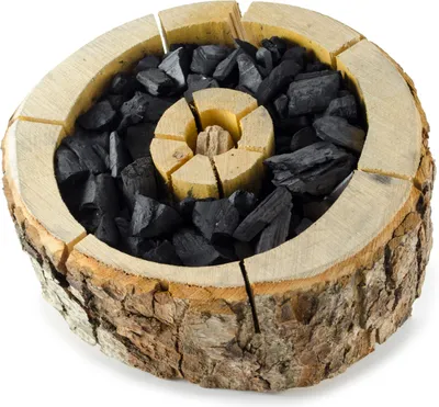 A close-up, top-down view of a disposable grill made from a hollowed-out log filled with charcoal.