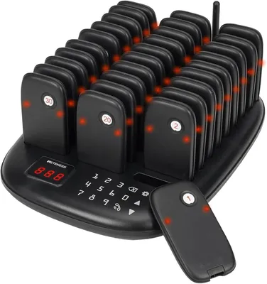 A black restaurant pager system with multiple pagers charging on a base station.