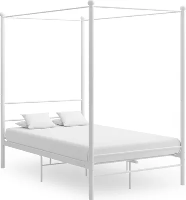 A white metal canopy bed with two white pillows on the mattress.