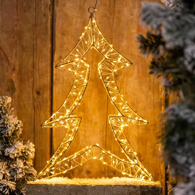 A decorative LED Christmas tree with warm white lights against a wooden background.