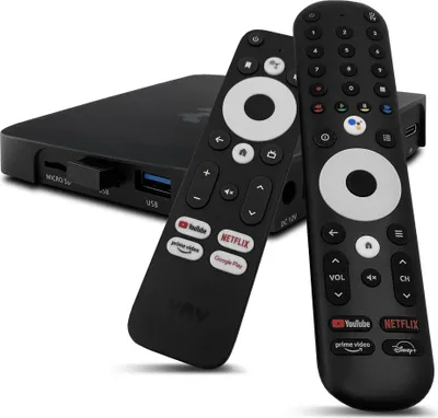 A black streaming box with two black remote controls in front of it, on a white background.