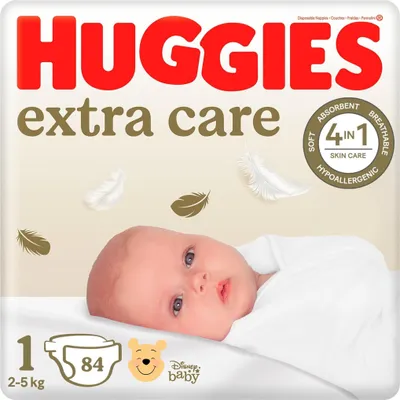 A close-up of a baby lying down, with Huggies Extra Care packaging in the background.