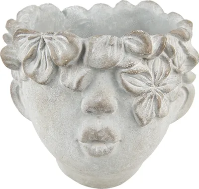 A close-up studio shot of a gray stone planter shaped like a face with flowers around the top.
