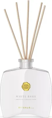 A white glass diffuser bottle with white basil fragrance sticks.