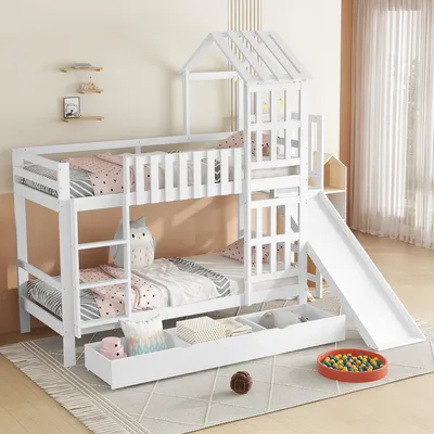 A white wooden bunk bed with a slide and storage drawers, set up in a child's bedroom.