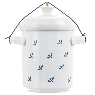 A white ceramic pot with blue floral decorations and a string handle.