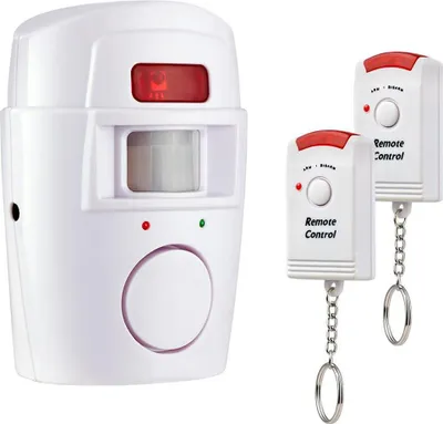 A white motion alarm sensor with a red light and two white remote controls with red tops are displayed against a white background.