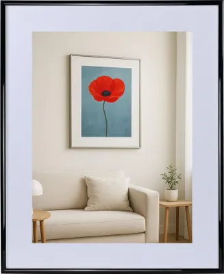 A framed picture of a red poppy on a blue background hangs above a sofa in a living room.
