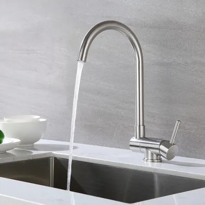 A stainless steel kitchen faucet with water running into a sink.
