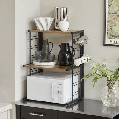 A kitchen counter with a microwave stand holding various kitchen items.
